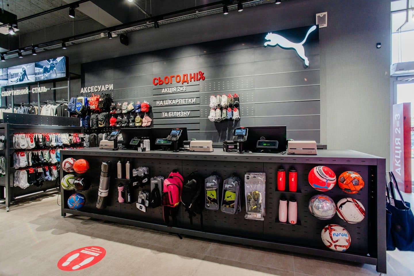 Interno di un negozio di articoli sportivi con bancone cassa e merce.